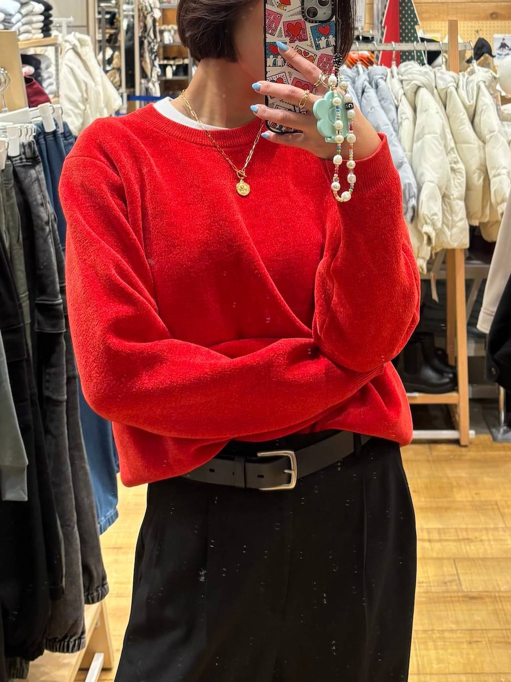 ブラック系のその他パンツ、レッド系のニット/セーター、ゴールド系のピアス(両耳用)を着用したレディースの冬コーディネートの2枚目の写真