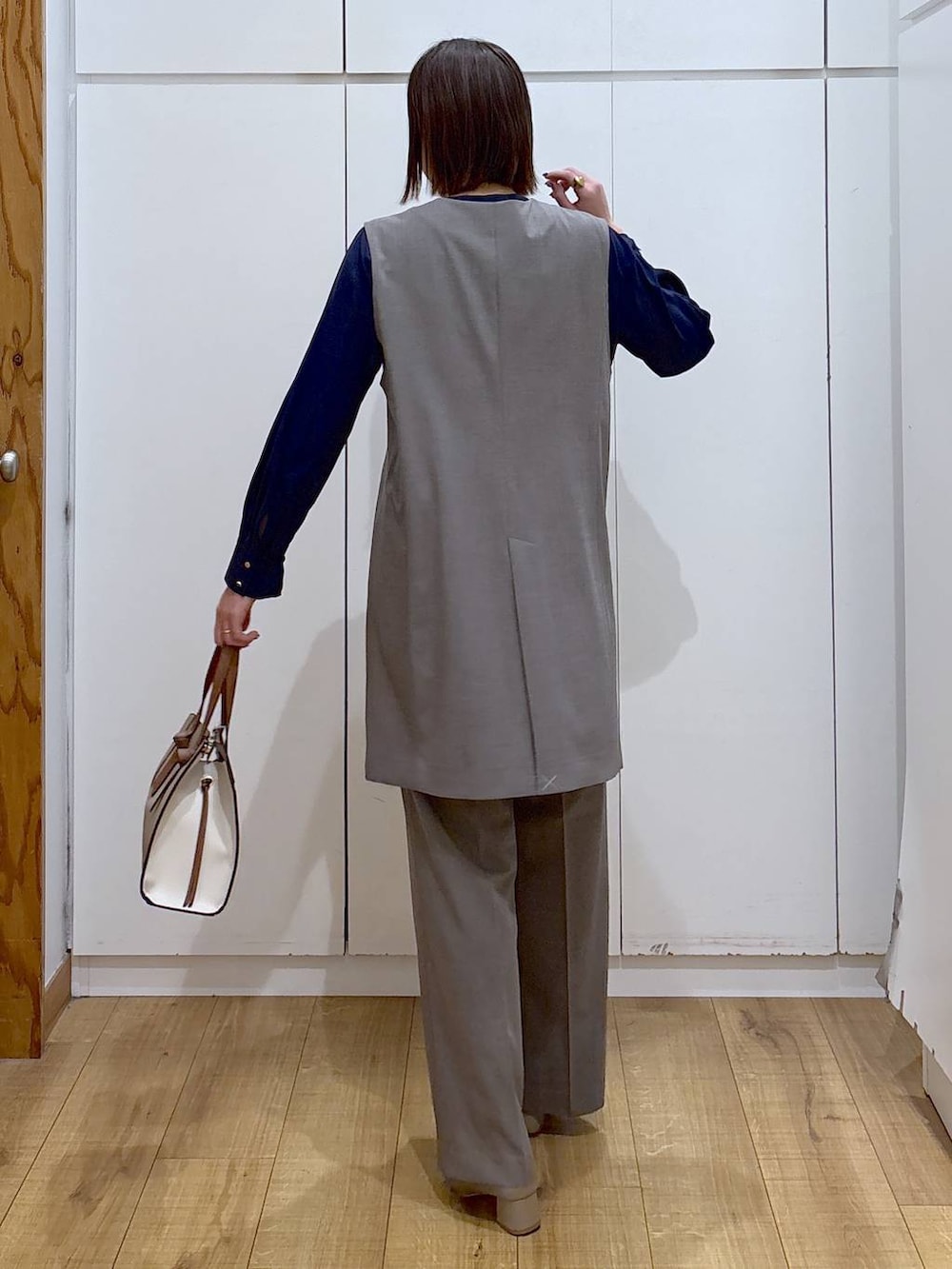 ベージュ系のローファー、ホワイト系のショルダーバッグ、ブラウン系のスラックスを着用したレディースの冬コーディネートの3枚目の写真