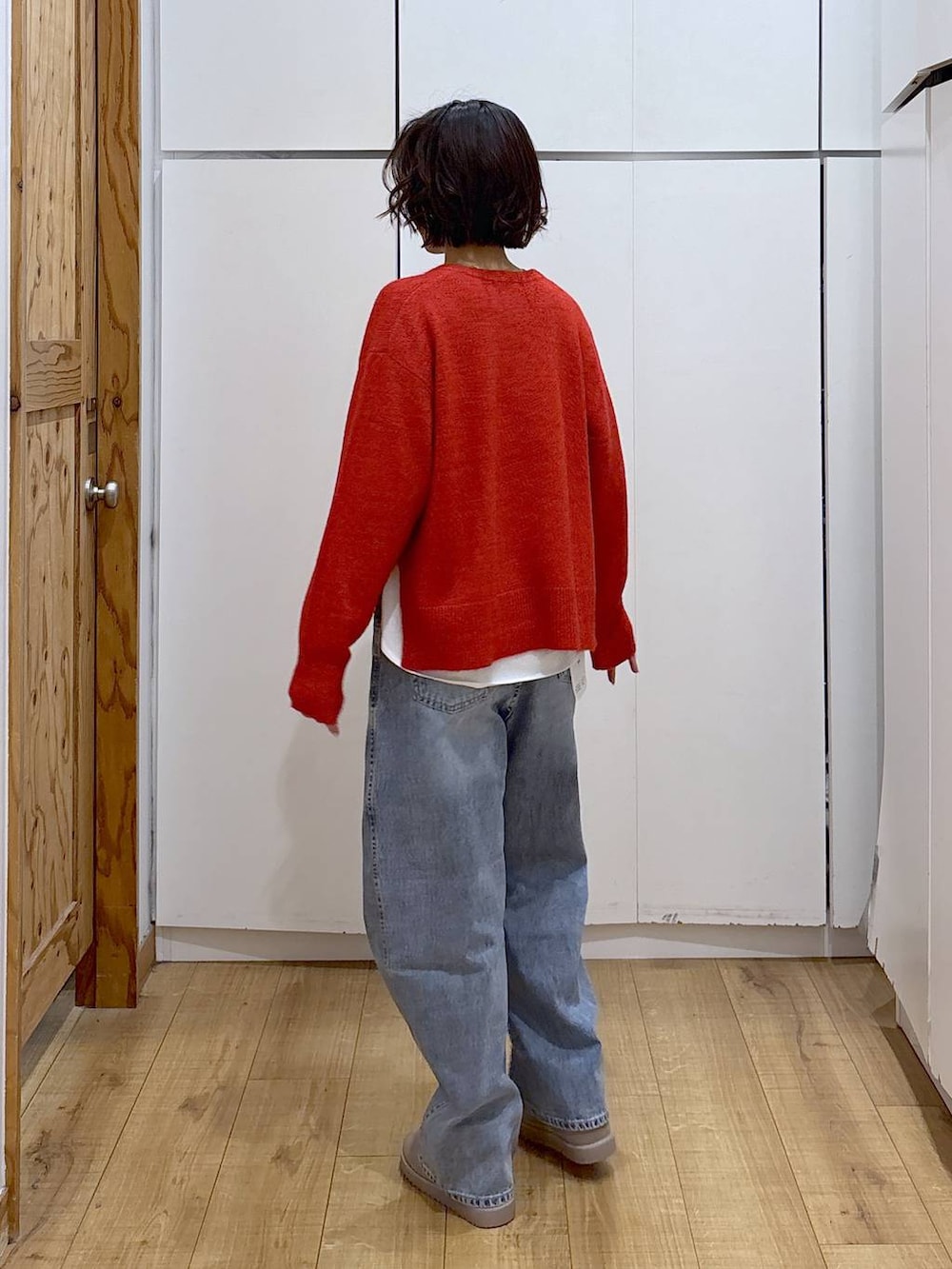 ブルー系のデニムパンツ、レッド系のニット/セーター、ホワイト系のTシャツ/カットソーを着用したレディースの冬コーディネートの7枚目の写真