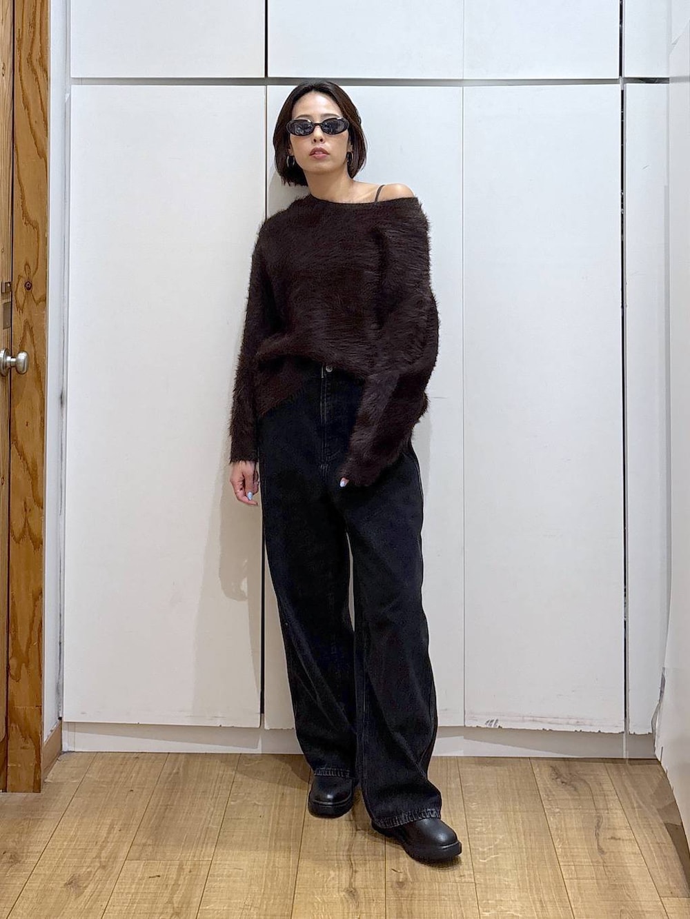 ブラック系のデニムパンツ、ブラック系のブーツ、ブラウン系のニット/セーターを着用したレディースの冬コーディネートの2枚目の写真