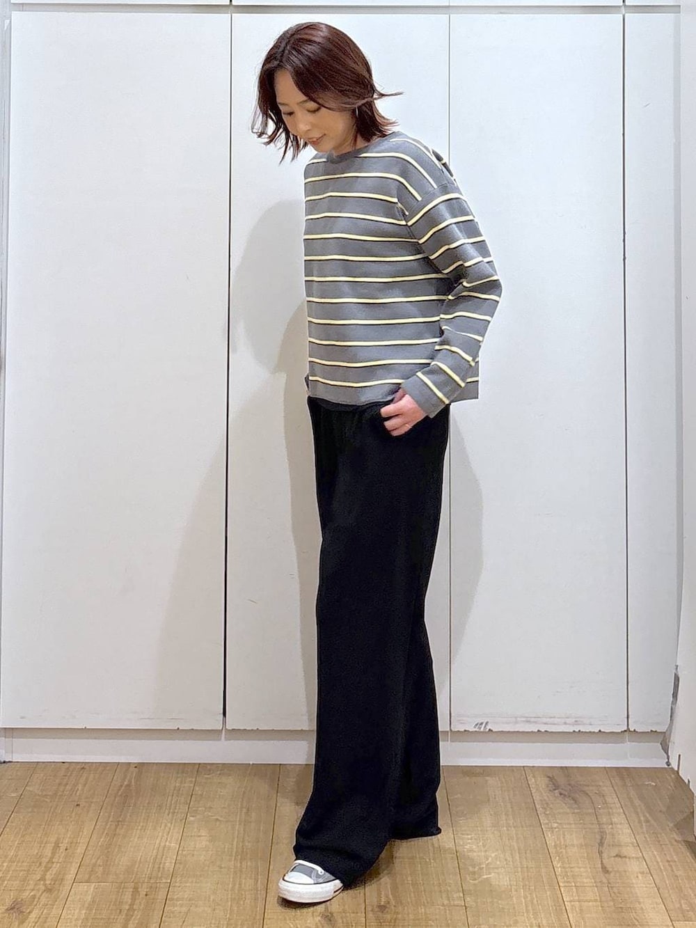 グレー系のニット/セーター、ブラック系のその他パンツを着用したレディースの春コーディネートの2枚目の写真