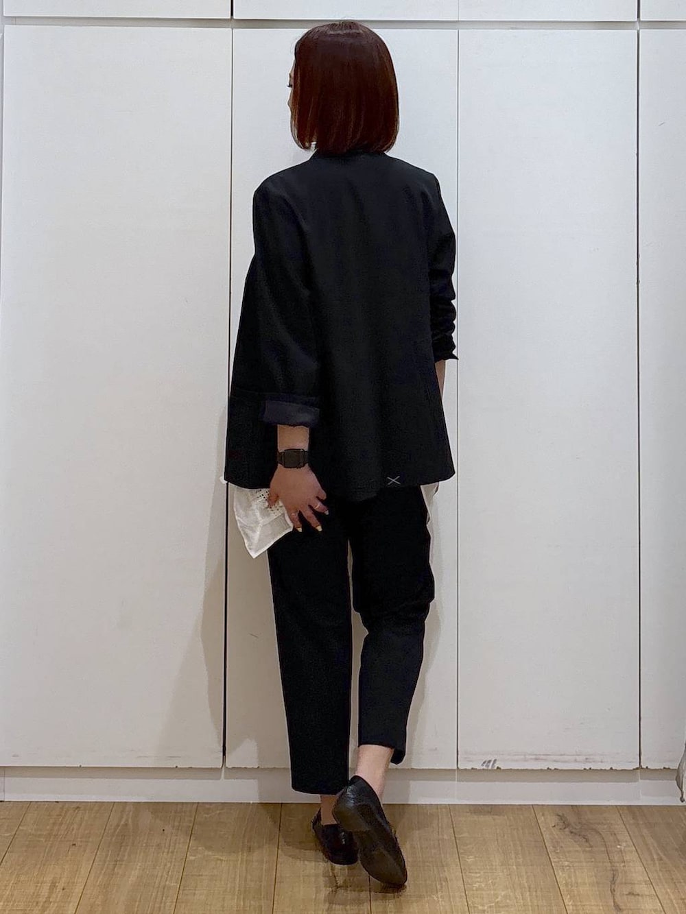 ブラック系のローファー、ブラック系のスラックス、ブラック系のノーカラージャケットを着用したレディースの春コーディネートの5枚目の写真