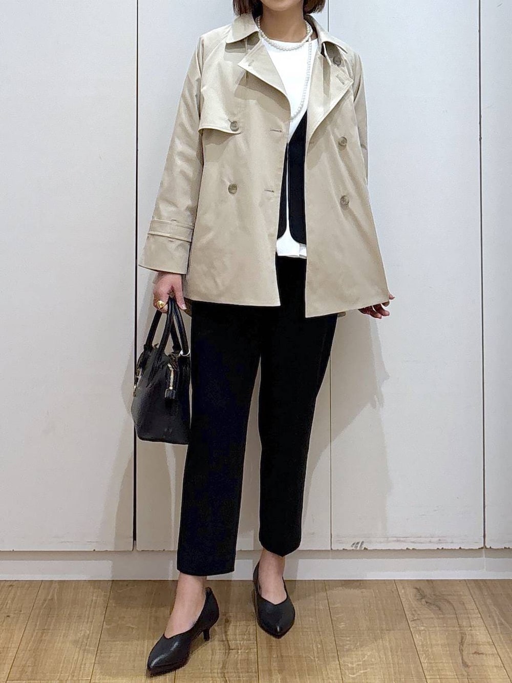 ブラック系のショルダーバッグ、ブラック系のパンプス、ブラック系のセットアップを着用したレディースの冬コーディネートの2枚目の写真