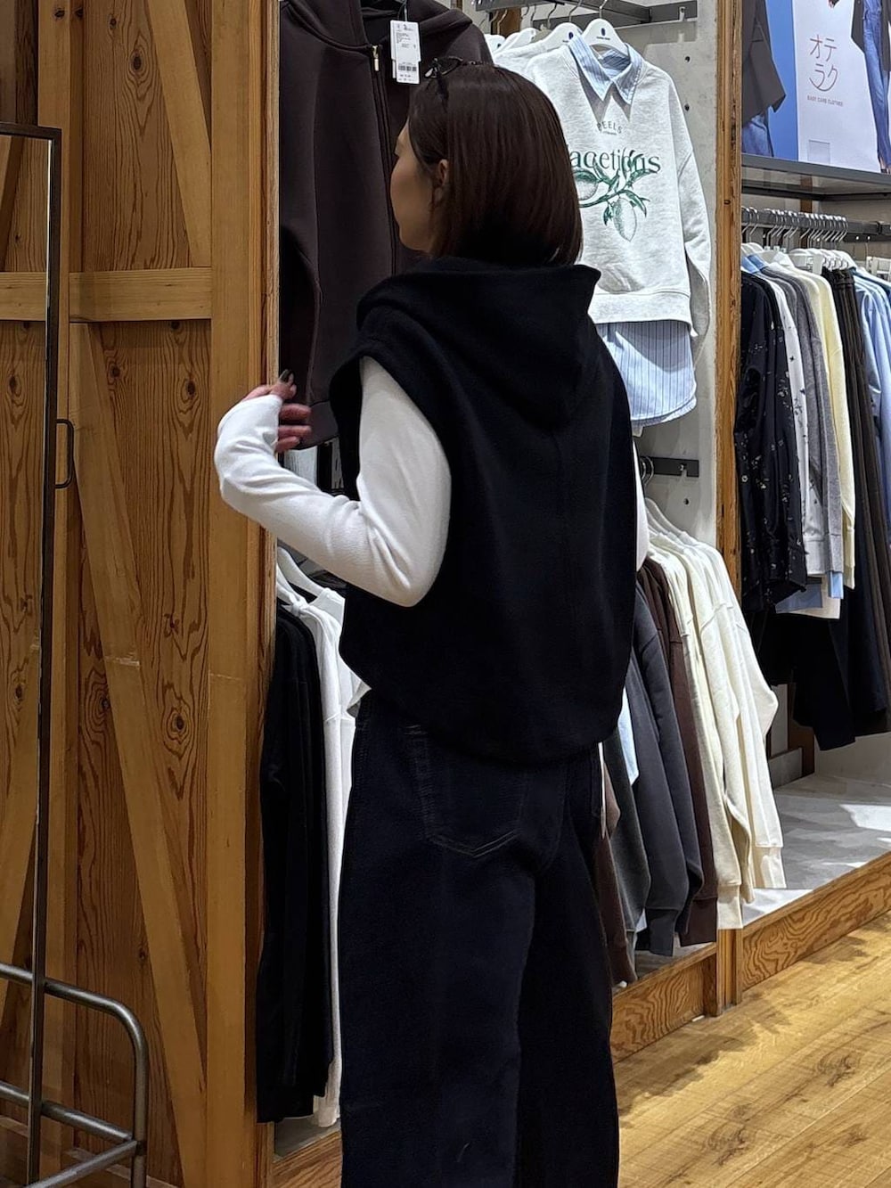 ブルー系のデニムパンツ、ブラック系のベストを着用したレディースの冬コーディネートの9枚目の写真