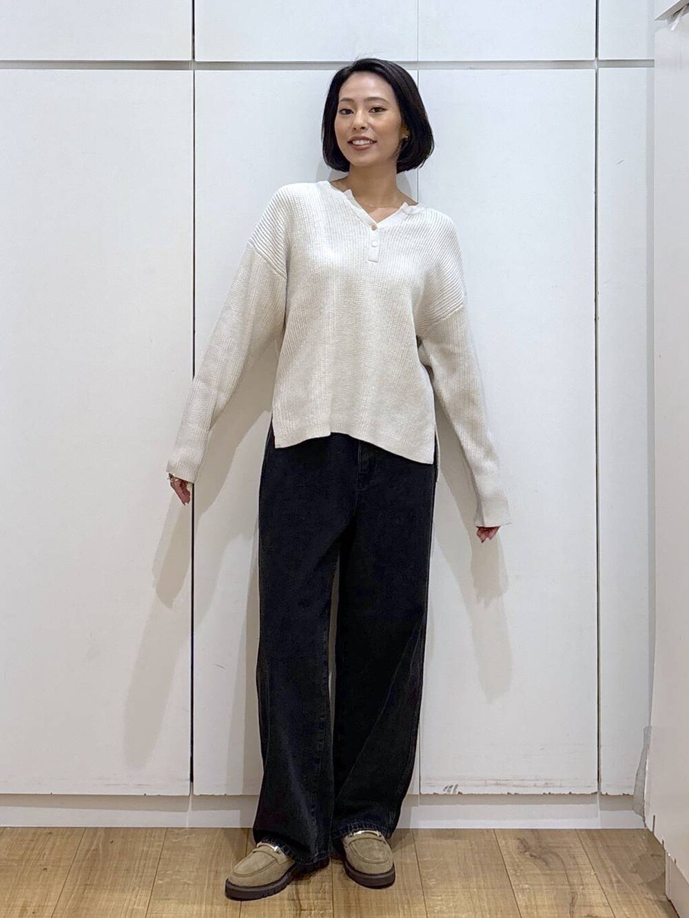 ブラック系のデニムパンツ、ベージュ系のローファー、ベージュ系のニット/セーターを着用したレディースの秋コーディネートの3枚目の写真