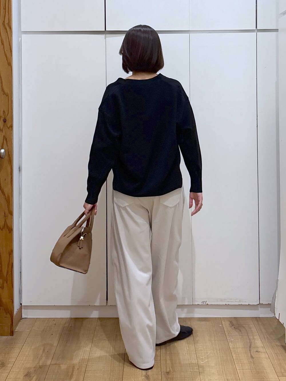 ブラック系のカーディガン/ボレロ、グレー系のその他パンツ、ベージュ系のショルダーバッグを着用したレディースの秋コーディネートの4枚目の写真