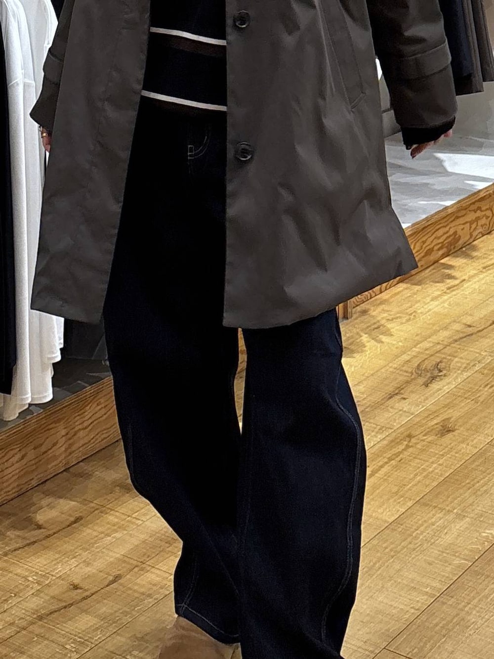 ブラウン系のステンカラーコート、ブルー系のデニムパンツを着用したレディースの冬コーディネートの5枚目の写真