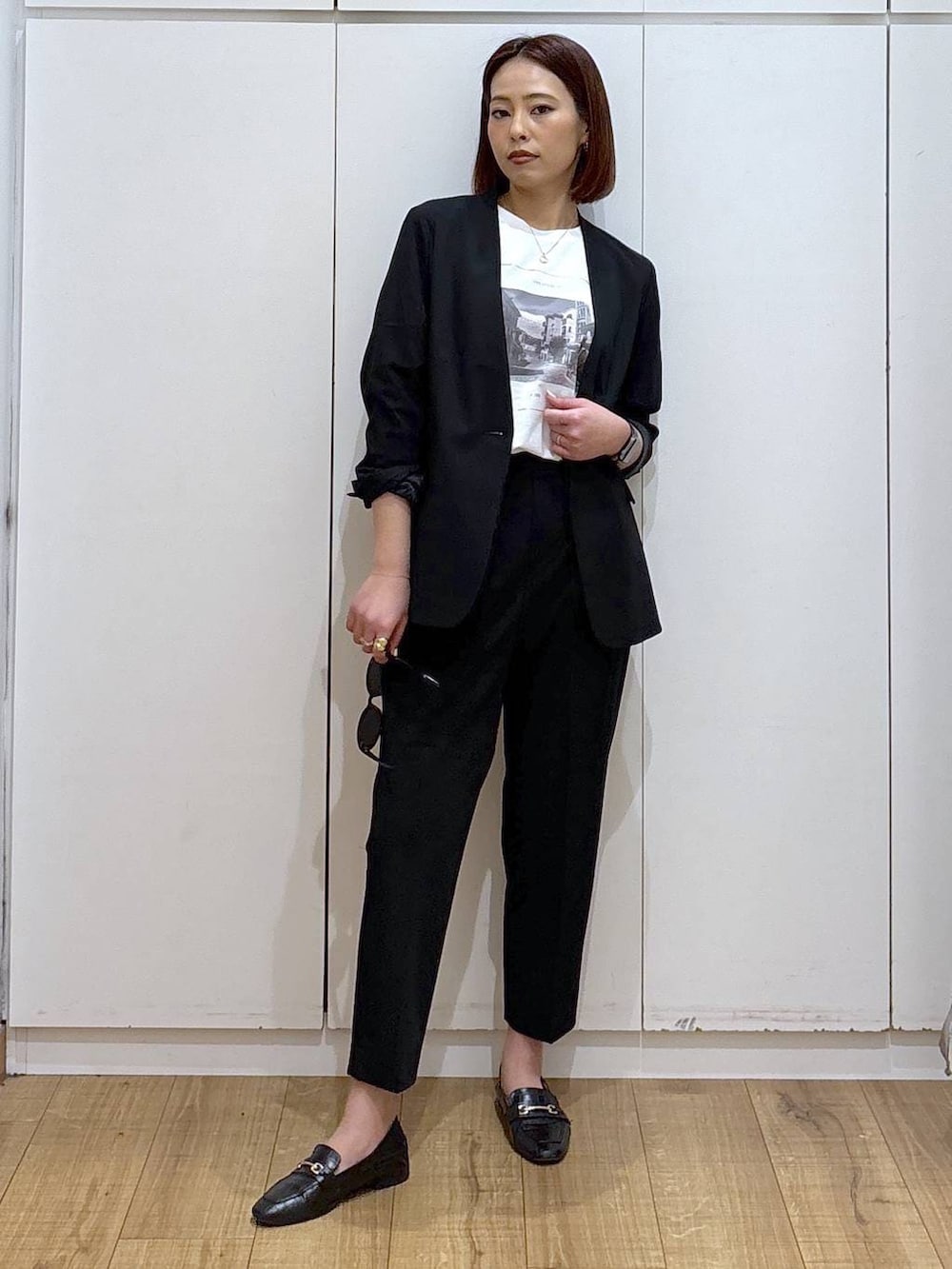 ブラック系のローファー、ブラック系のスラックス、ブラック系のノーカラージャケットを着用したレディースの春コーディネートの3枚目の写真