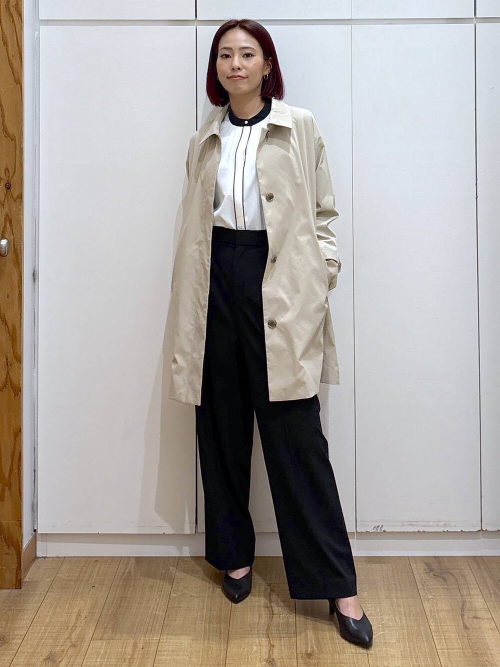 ブラック系のパンプス、ホワイト系のシャツ/ブラウス、ブラック系のスラックスを着用したレディースの春コーディネートの2枚目の写真