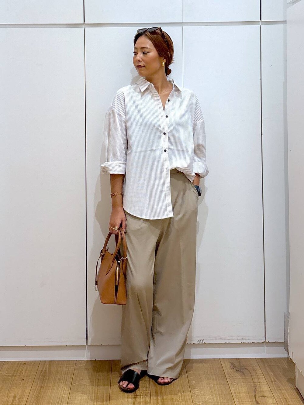 ブラウン系のショルダーバッグ、ベージュ系のその他パンツ、その他のシャツ/ブラウスを着用したレディースの秋コーディネートの3枚目の写真