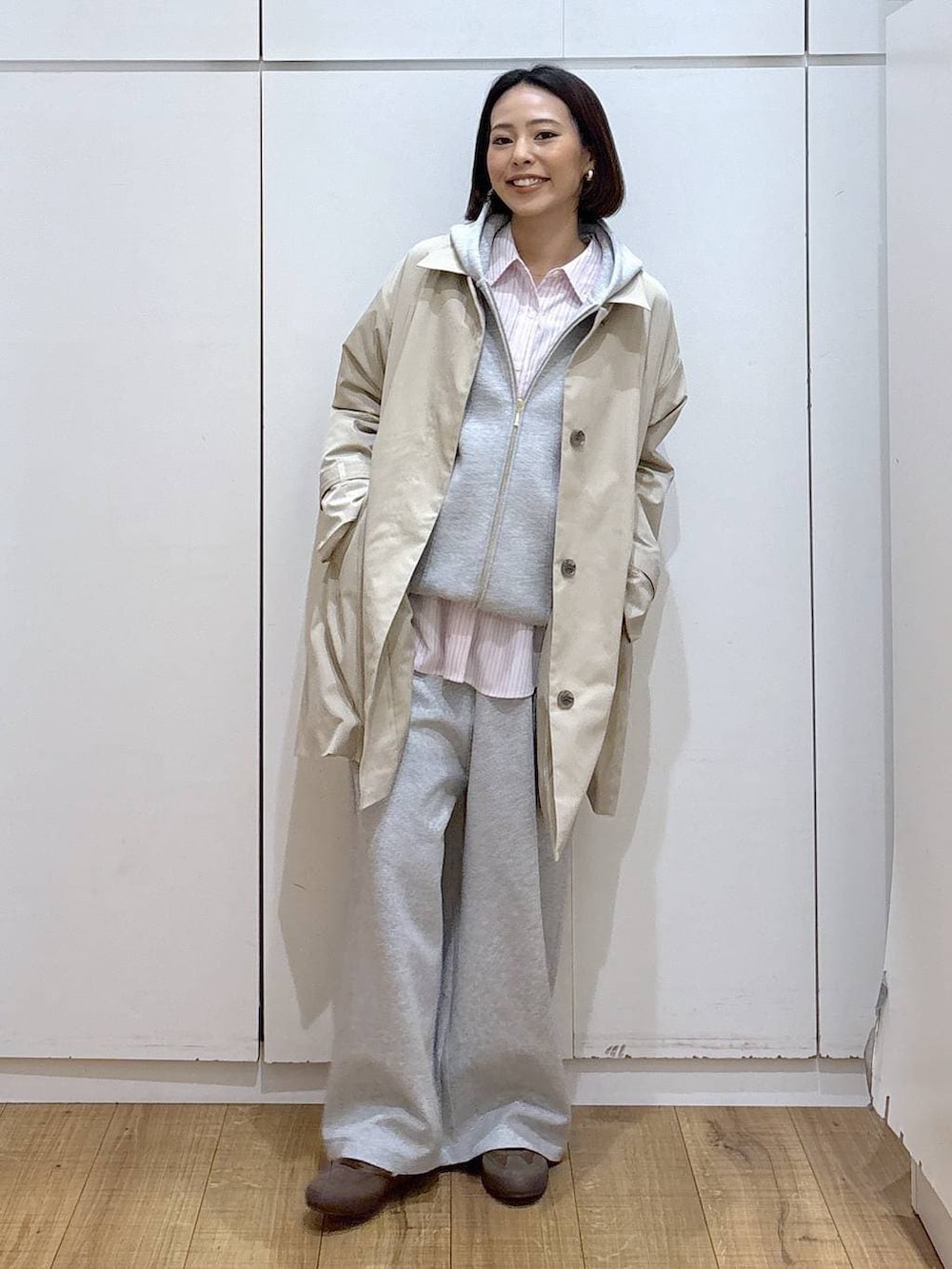 ブラウン系のスニーカー、ピンク系のシャツ/ブラウス、ベージュ系のステンカラーコートを着用したレディースの冬コーディネートの4枚目の写真