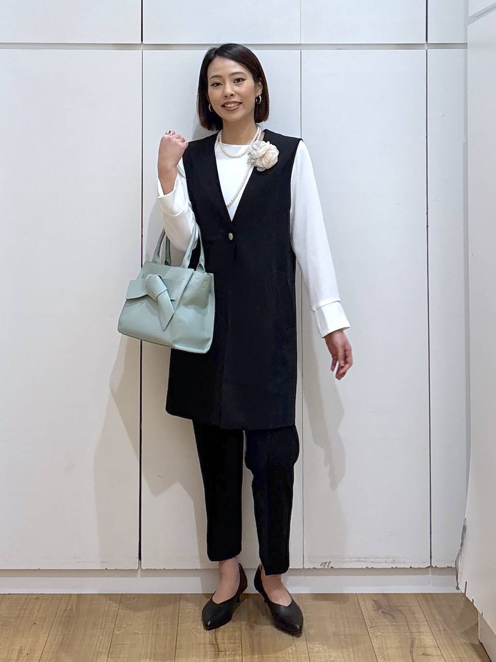 ブラック系のパンプス、ブラック系のスラックス、ブラック系のセットアップを着用したレディースの冬コーディネートの4枚目の写真