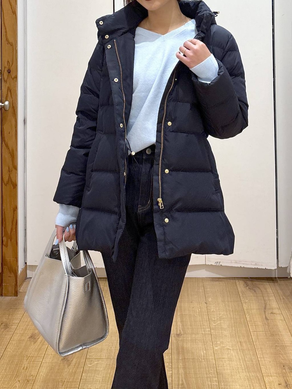 ブルー系のダウンジャケット/コート、ブルー系のデニムパンツ、シルバー系のトートバッグを着用したレディースの冬コーディネートの7枚目の写真