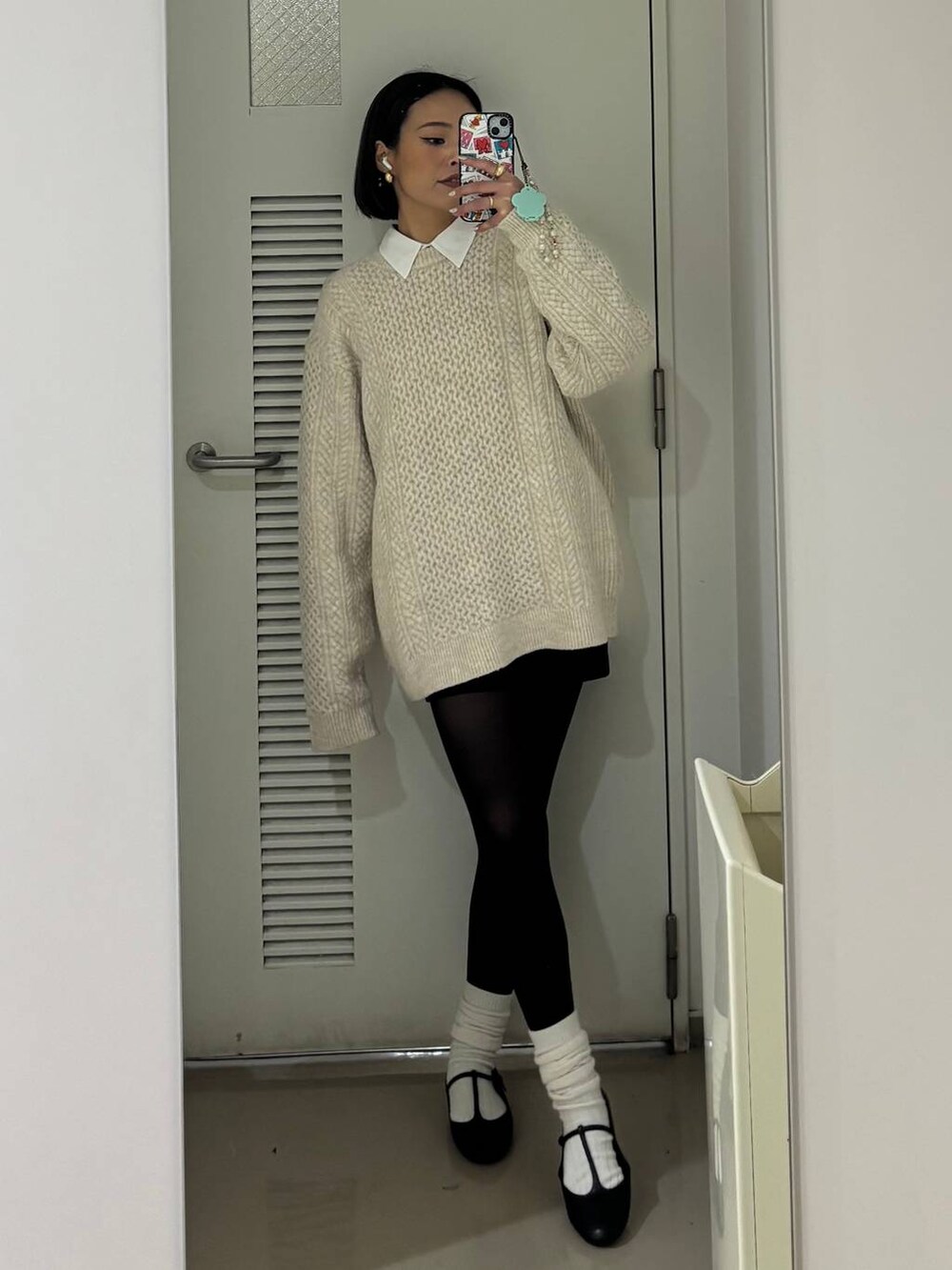 ホワイト系のシャツ/ブラウス、ホワイト系のニット/セーター、ブラック系のカチューシャを着用したレディースの冬コーディネートの3枚目の写真