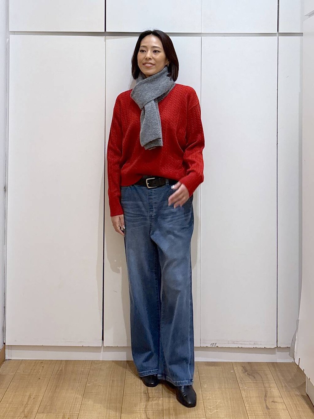 ブルー系のチェスターコート、ブラック系のブーツ、ブルー系のデニムパンツを着用したレディースの秋コーディネートの5枚目の写真