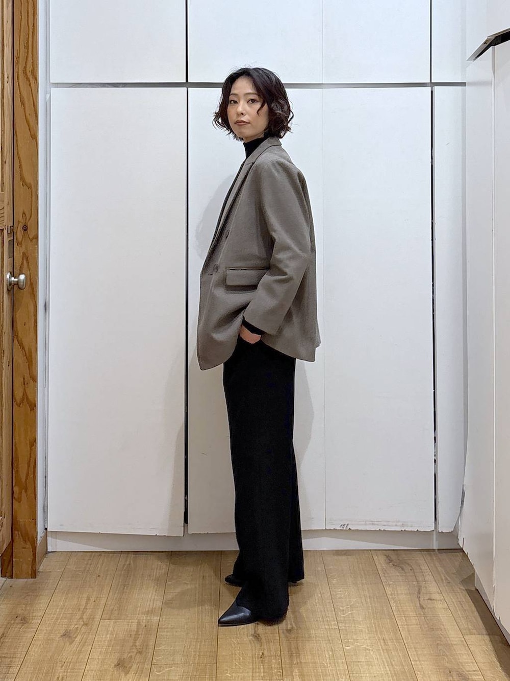 ブラック系のその他パンツ、ブラック系のニット/セーター、ブラウン系のテーラードジャケットを着用したレディースの冬コーディネートの3枚目の写真