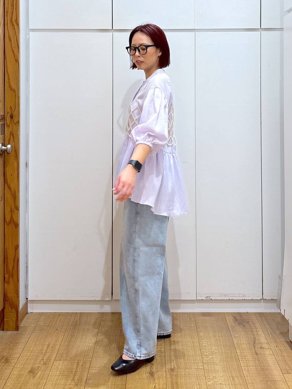 ホワイト系のベスト、ブルー系のデニムパンツ、ベージュ系のトレンチコートを着用したレディースの春コーディネートの7枚目の写真