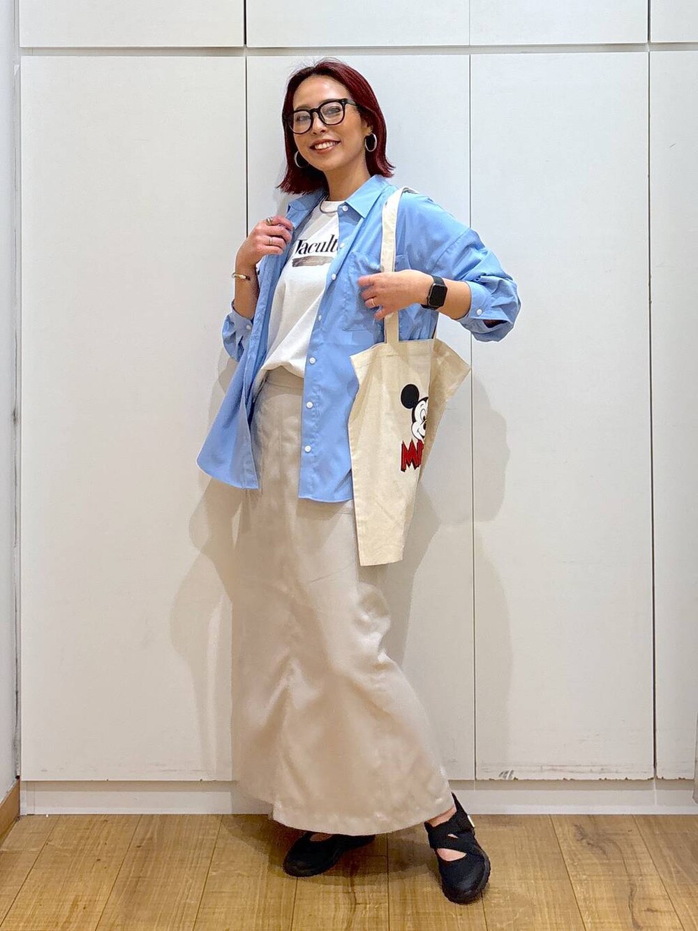 ブラック系のスニーカー、ホワイト系のTシャツ/カットソー、ブルー系のシャツ/ブラウスを着用したレディースの春コーディネートの2枚目の写真