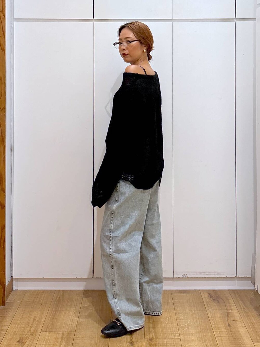 ブラック系のローファー、ブルー系のデニムパンツ、ブラック系のニット/セーターを着用したレディースの秋コーディネートの3枚目の写真