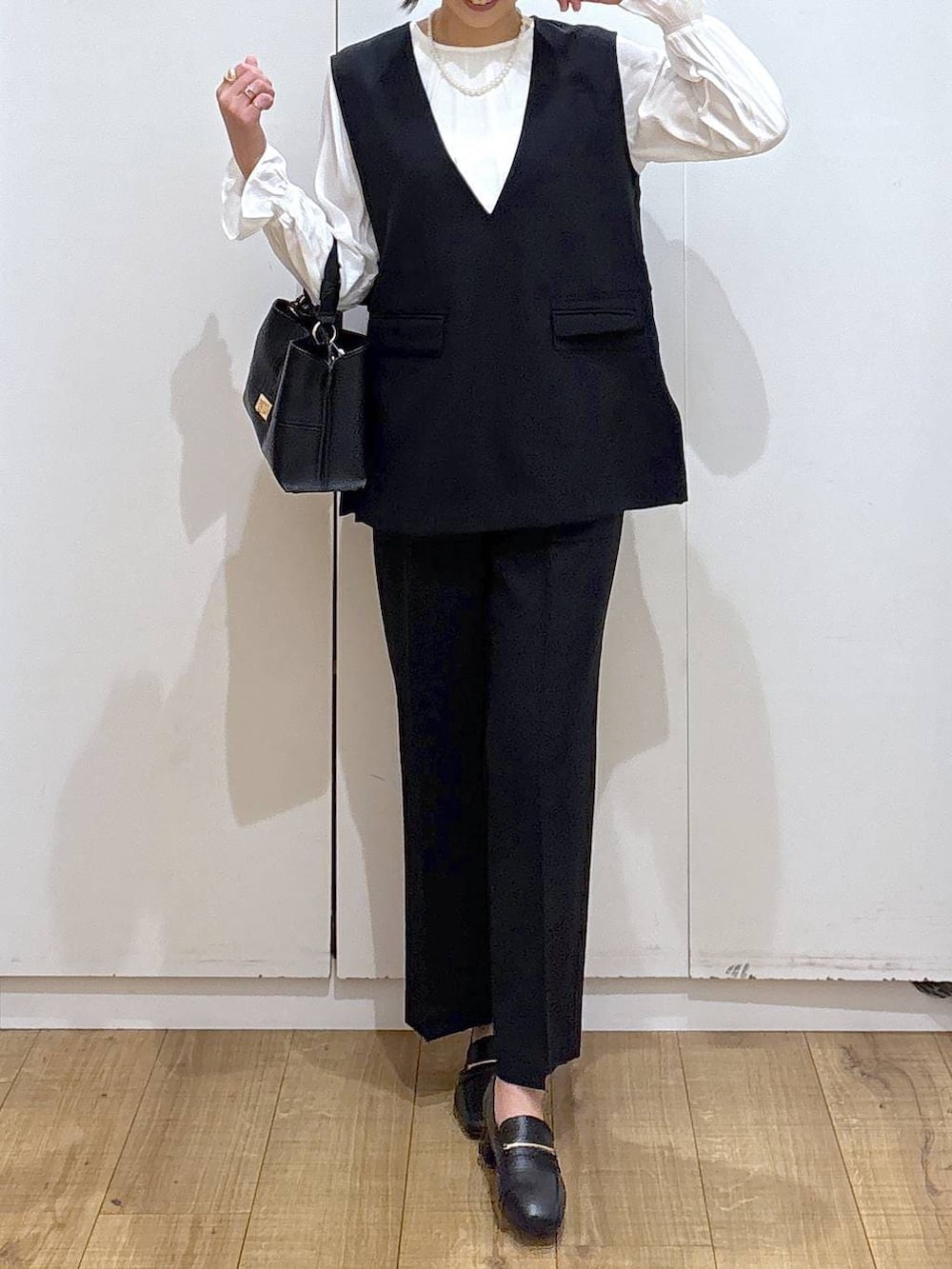 ブラック系のローファー、ブラック系のセットアップ、ブラック系のショルダーバッグを着用したレディースの冬コーディネートの6枚目の写真