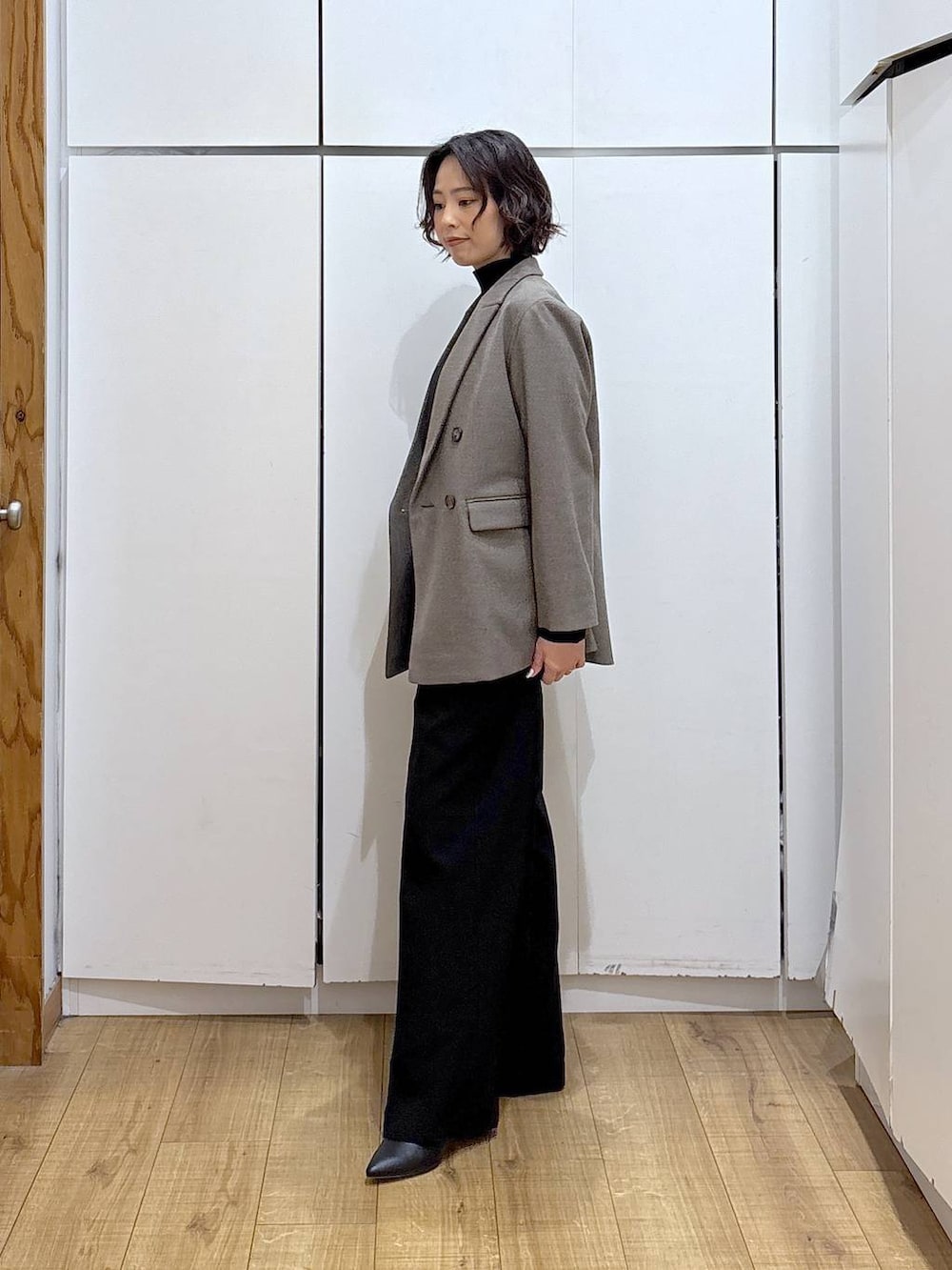 ブラック系のその他パンツ、ブラック系のニット/セーター、ブラウン系のテーラードジャケットを着用したレディースの冬コーディネートの4枚目の写真