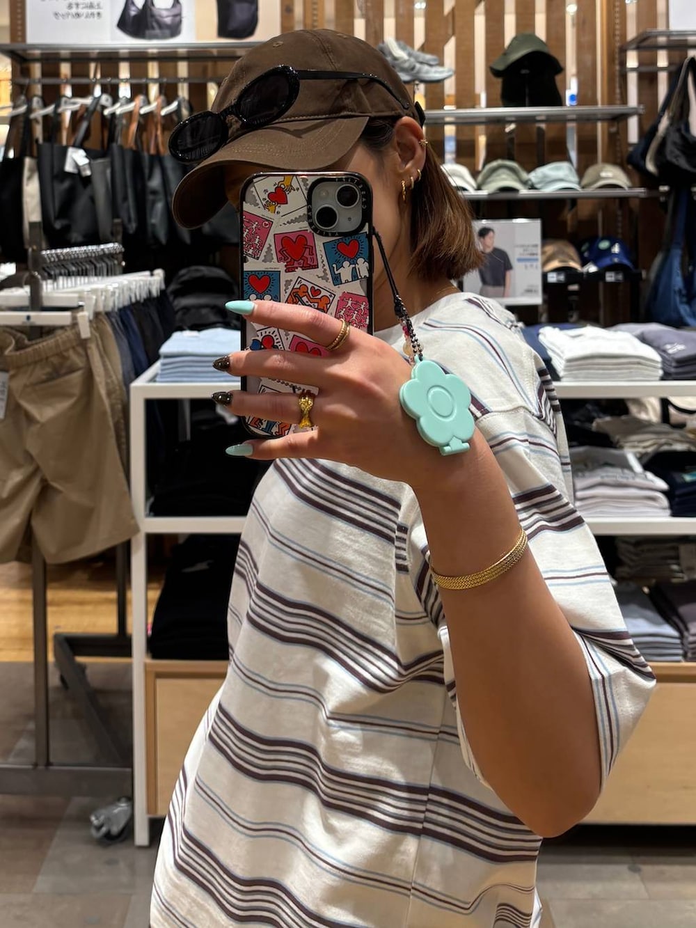 ブラウン系のデニムパンツ、ブラック系のスニーカー、ホワイト系のTシャツ/カットソーを着用したレディースの春コーディネートの3枚目の写真