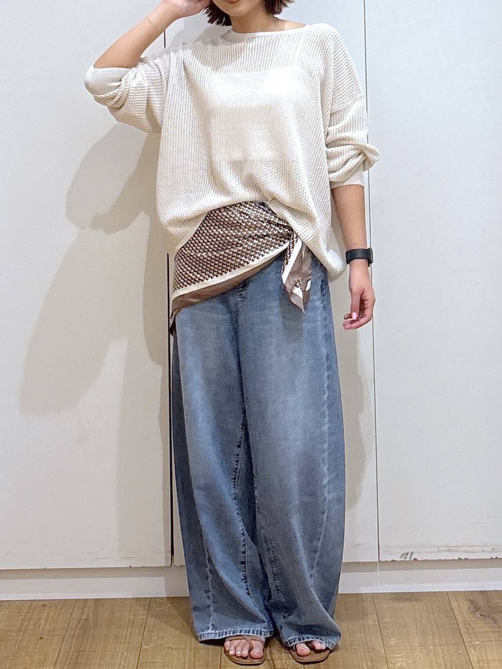 ホワイト系のキャミソール、ブルー系のデニムパンツ、ホワイト系のニット/セーターを着用したレディースの春コーディネートの2枚目の写真
