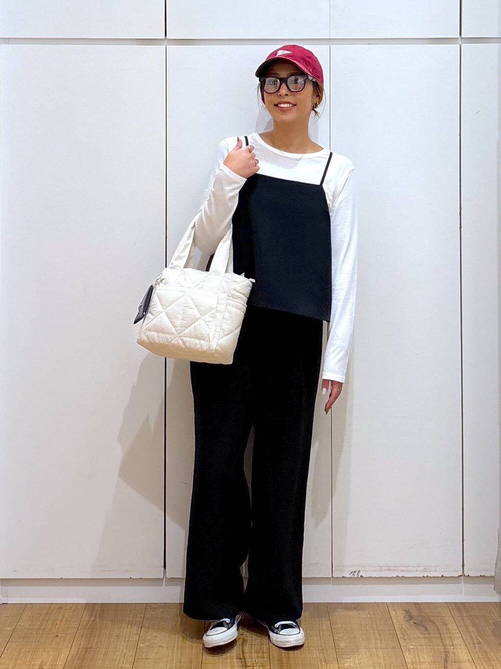 ホワイト系のトートバッグ、ブラック系のサロペット/オーバーオール、ブラック系のサングラスを着用したレディースの秋コーディネートの3枚目の写真