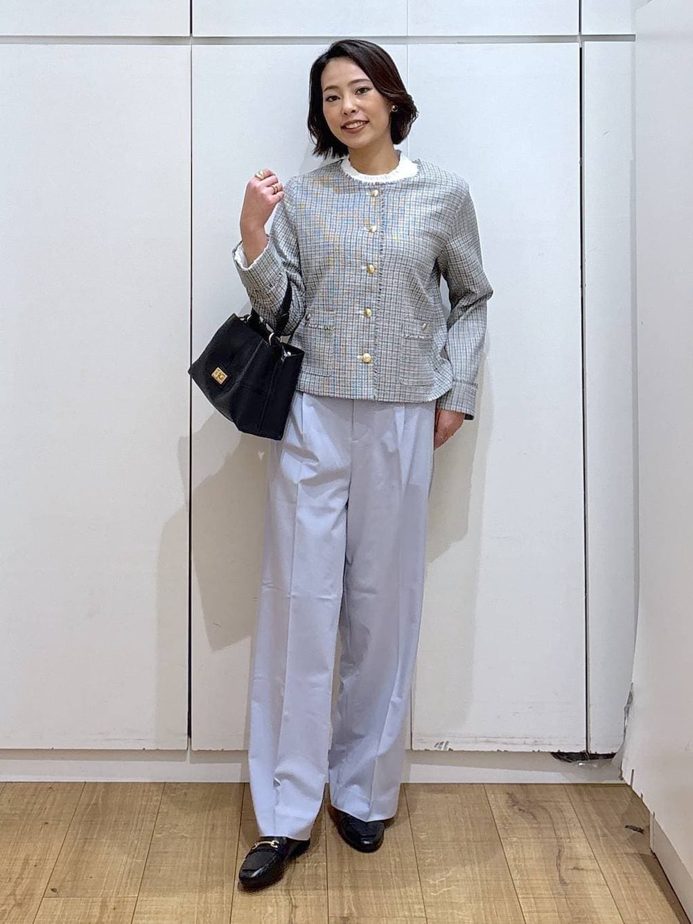 ブラック系のローファー、ブルー系のスラックス、ホワイト系のテーラードジャケットを着用したレディースの冬コーディネートの2枚目の写真