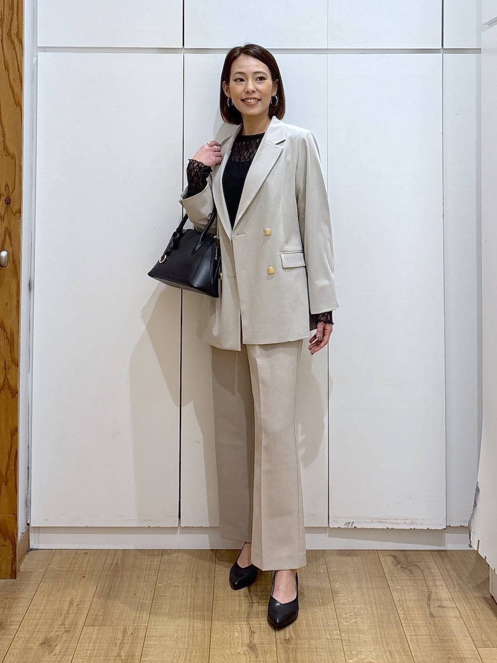 ブラック系のショルダーバッグ、ブラック系のパンプス、ブラック系のTシャツ/カットソーを着用したレディースの冬コーディネートの2枚目の写真