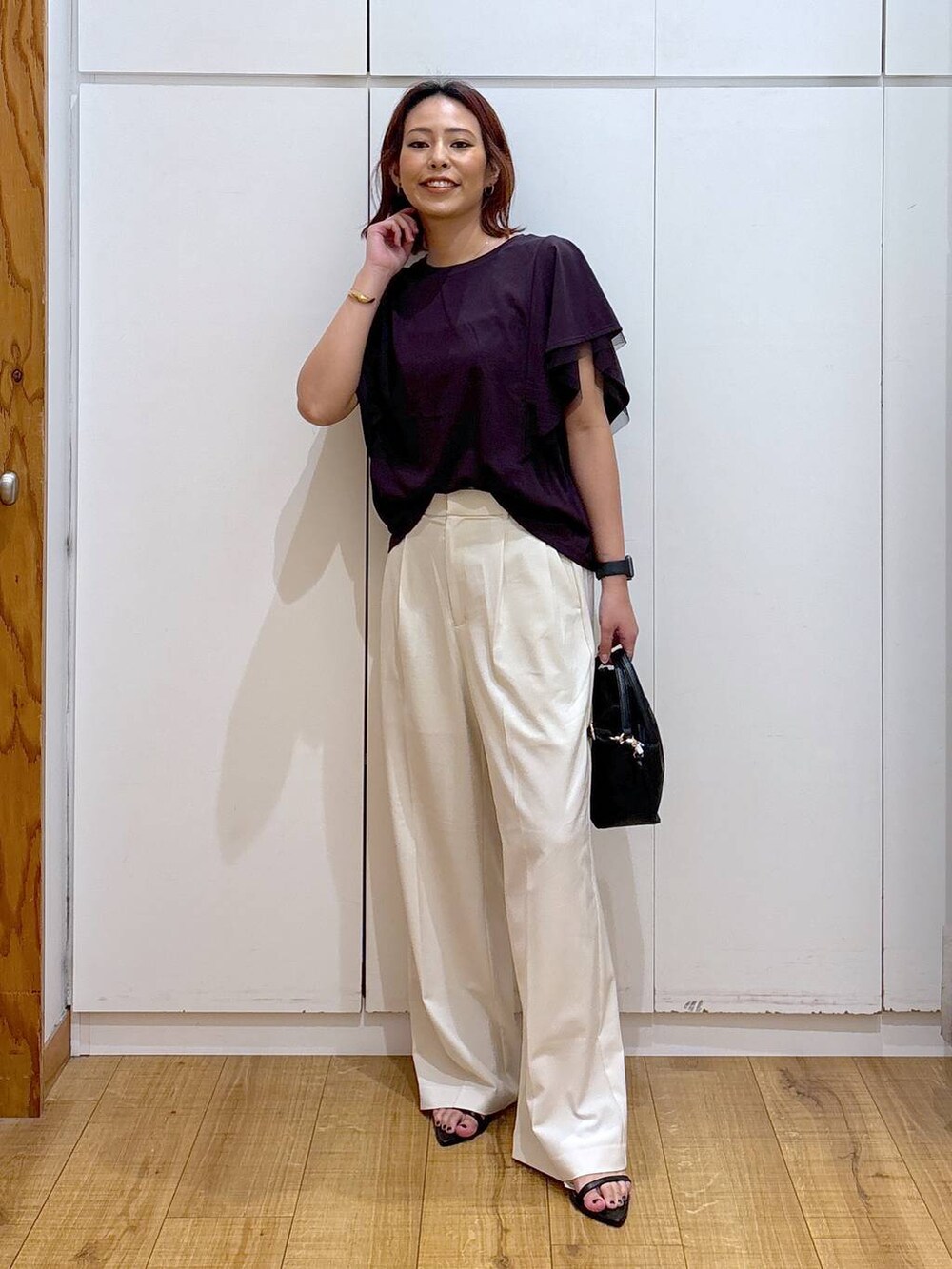 ブラック系のショルダーバッグ、ホワイト系のその他パンツ、ブラウン系のTシャツ/カットソーを着用したレディースの夏コーディネートの2枚目の写真