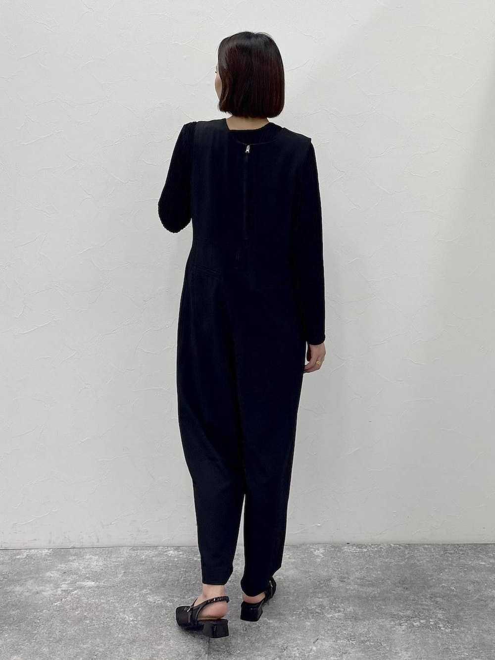 ブラック系のTシャツ/カットソー、ブラック系のサロペット/オーバーオール、ゴールド系のピアス（両耳用）を着用したレディースの冬コーディネートの3枚目の写真