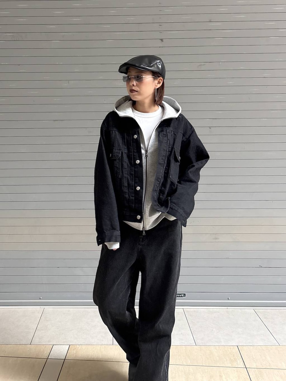 ブラック系のデニムパンツ、ブラック系のデニムジャケット、グレー系のパーカーを着用したレディースの冬コーディネートの8枚目の写真