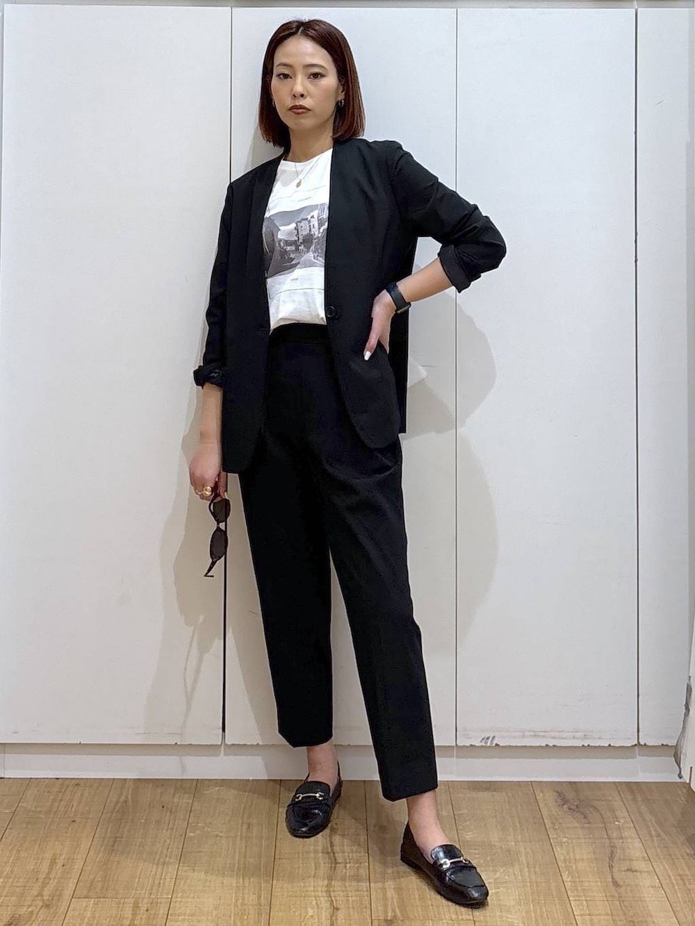 ブラック系のローファー、ブラック系のスラックス、ブラック系のノーカラージャケットを着用したレディースの春コーディネートの4枚目の写真