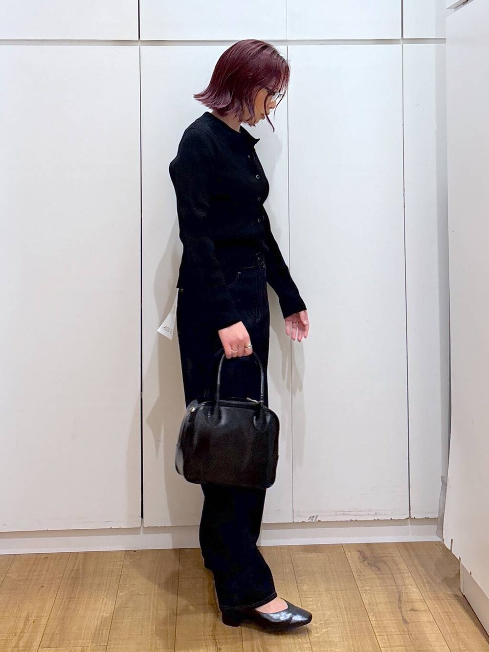 ブルー系のデニムパンツ、ブラック系のボストンバッグ、ブラック系のカーディガン/ボレロを着用したレディースの春コーディネートの5枚目の写真