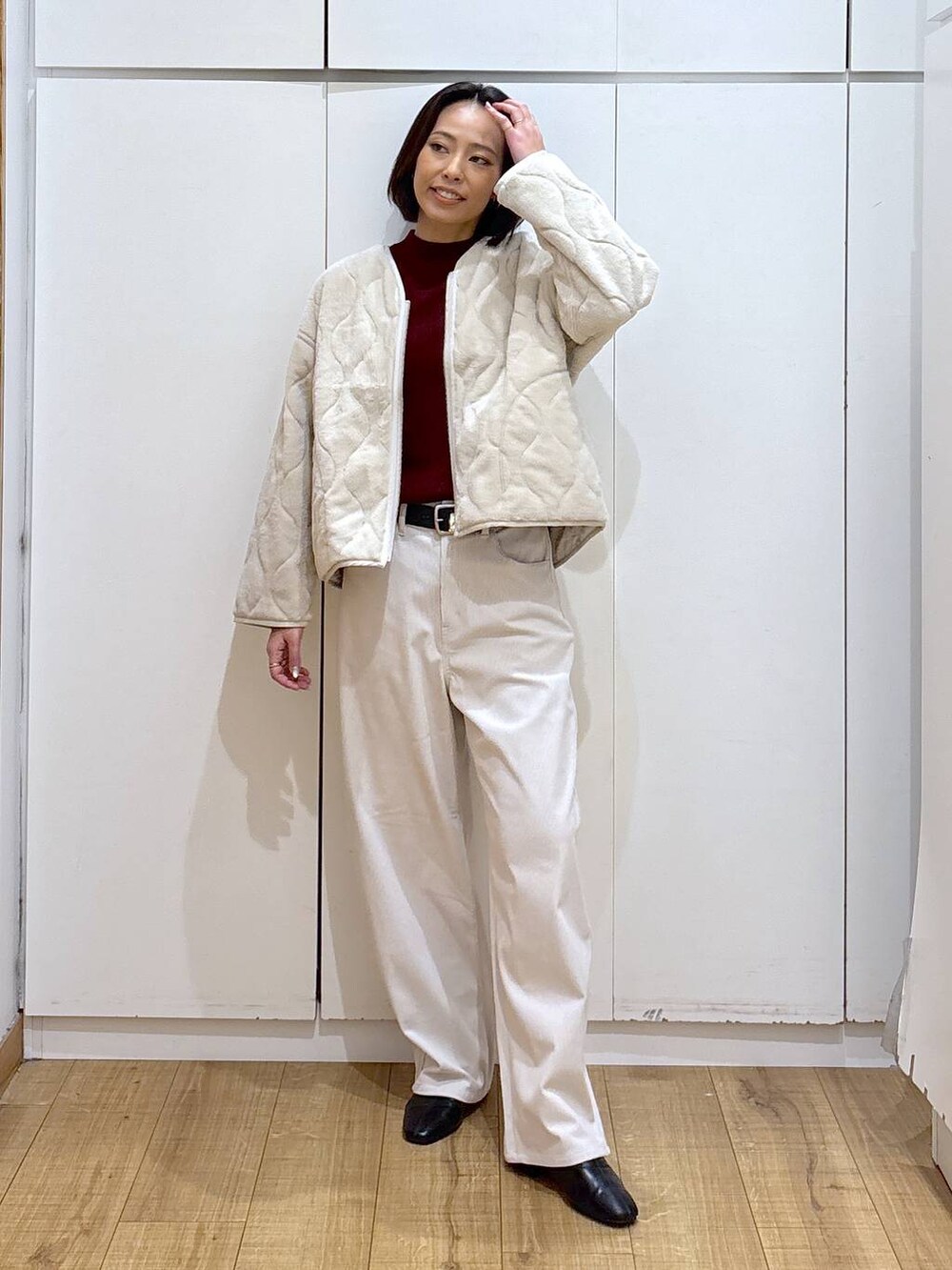 ベージュ系のブルゾン、レッド系のニット/セーター、グレー系のその他パンツを着用したレディースの秋コーディネートの2枚目の写真