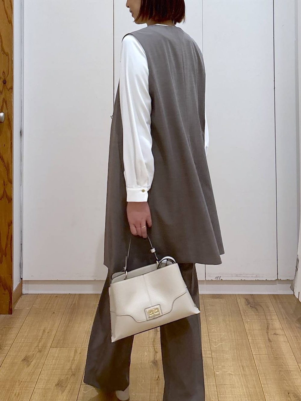 ブラウン系のスラックス、ホワイト系のシャツ/ブラウス、ブラウン系のその他アウターを着用したレディースの冬コーディネートの6枚目の写真