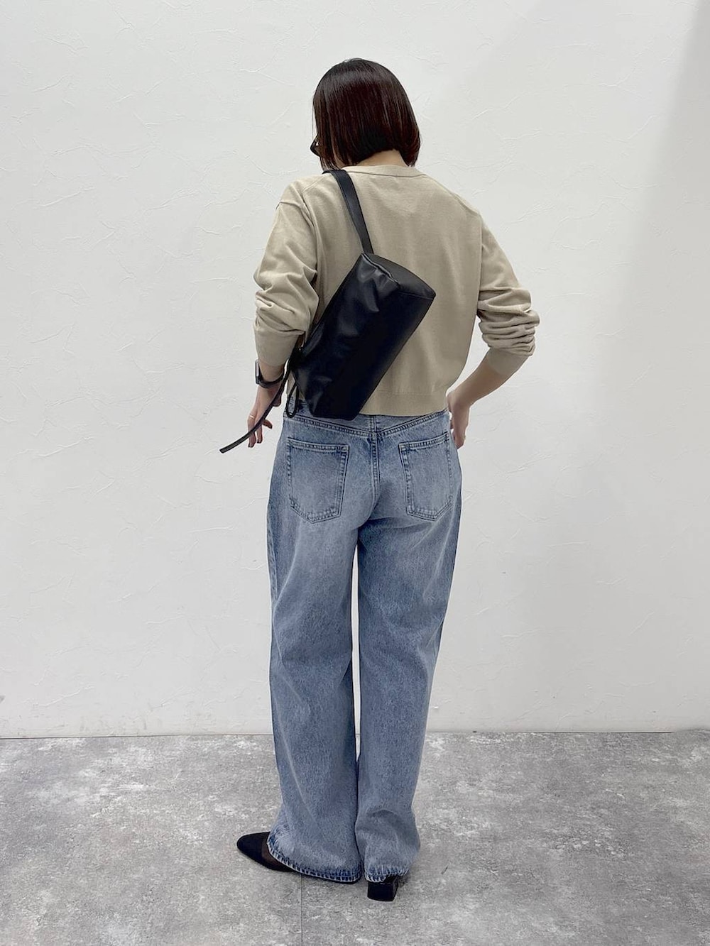 ブラック系のショルダーバッグ、ゴールド系のピアス（両耳用）、ゴールド系のリングを着用したレディースの冬コーディネートの6枚目の写真