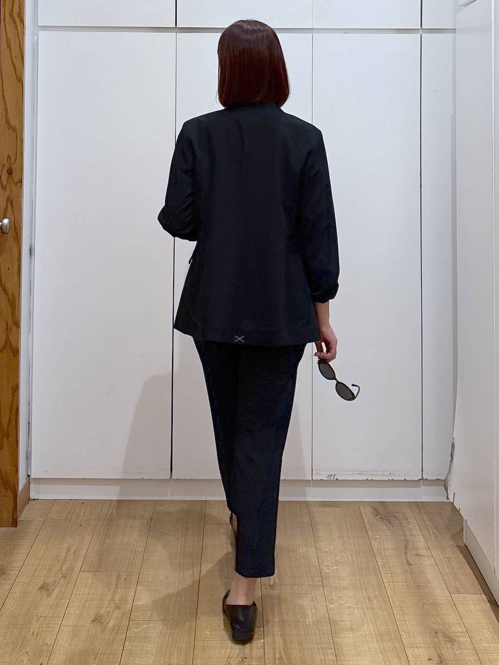 ブラック系のローファー、ブラック系のスラックス、ブラック系のノーカラージャケットを着用したレディースの春コーディネートの7枚目の写真