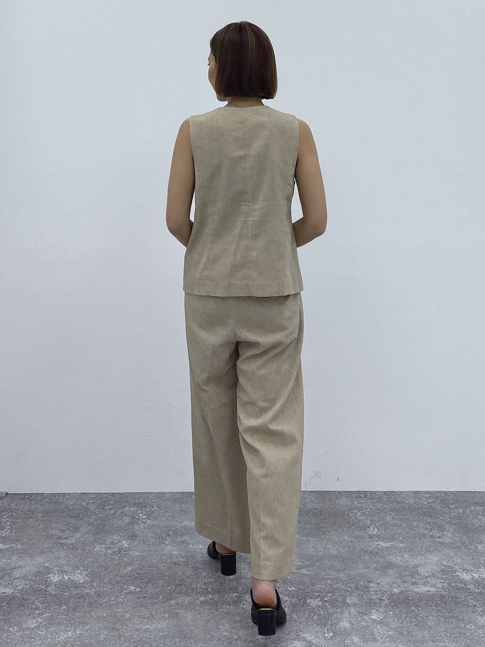 ベージュ系のその他パンツ、ベージュ系のベスト、ゴールド系のネックレスを着用したレディースの春コーディネートの5枚目の写真