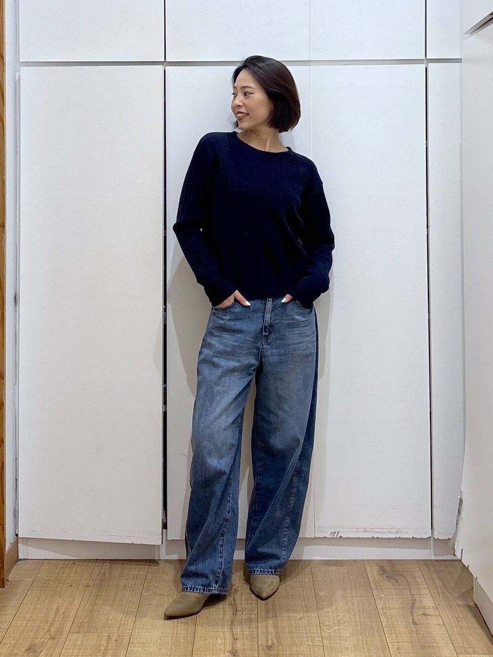 ブルー系のニット/セーター、ベージュ系のブーツ、ブルー系のデニムパンツを着用したレディースの冬コーディネートの2枚目の写真