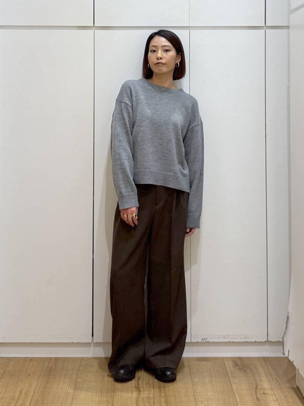 ブラック系のスニーカー、ブラウン系のその他パンツ、ゴールド系のピアス（両耳用）を着用したレディースの冬コーディネートの2枚目の写真