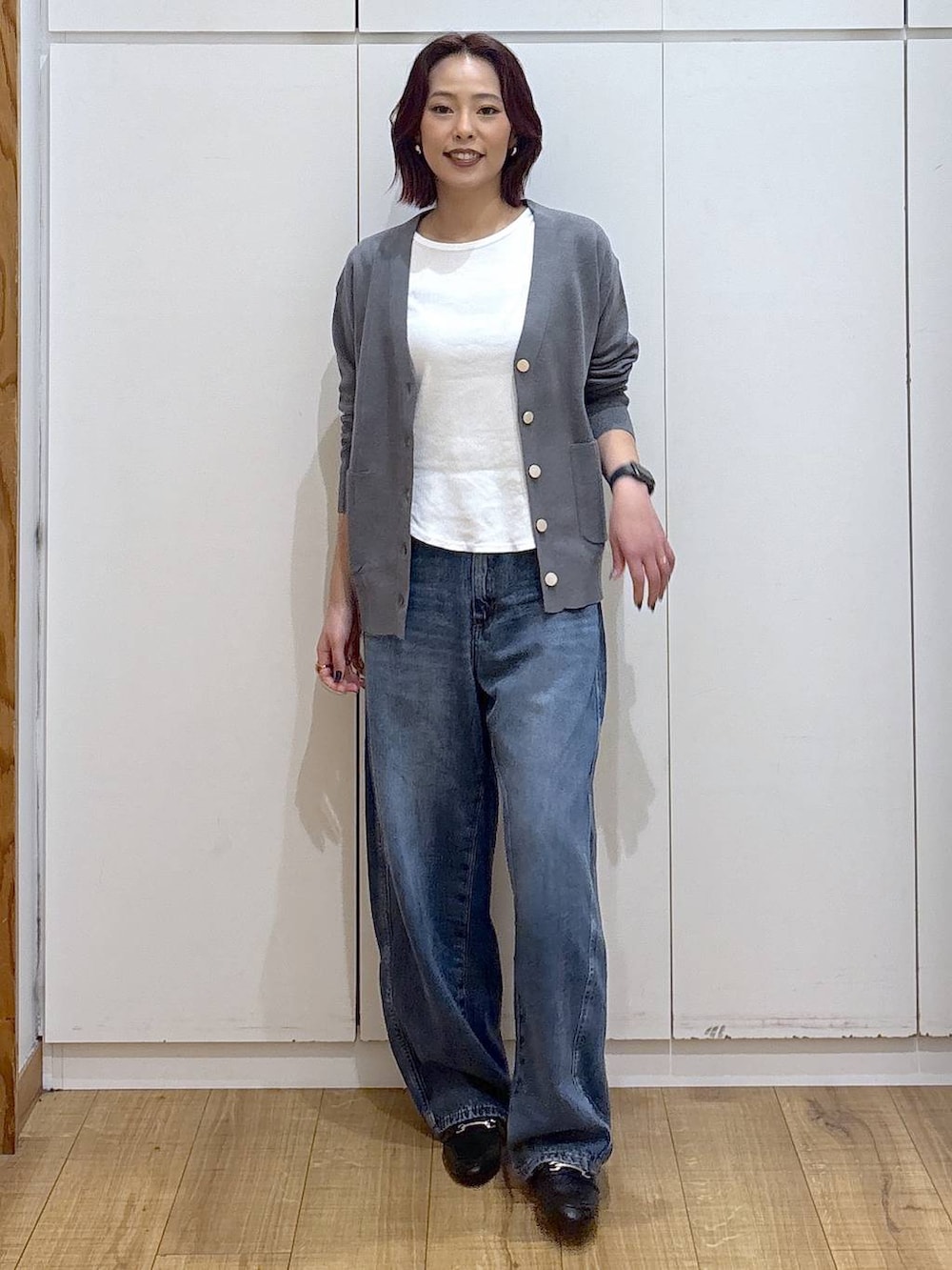 ブラック系のローファー、ブルー系のデニムパンツ、グレー系のカーディガン/ボレロを着用したレディースの春コーディネートの2枚目の写真