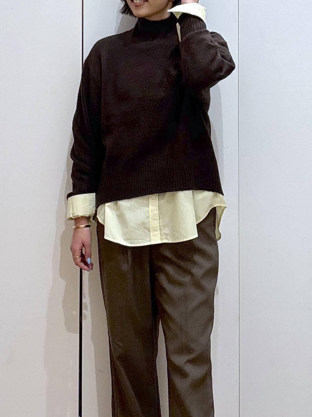イエロー系のシャツ/ブラウス、ブラウン系のニット/セーター、ブラウン系のその他パンツを着用したレディースの冬コーディネートの3枚目の写真