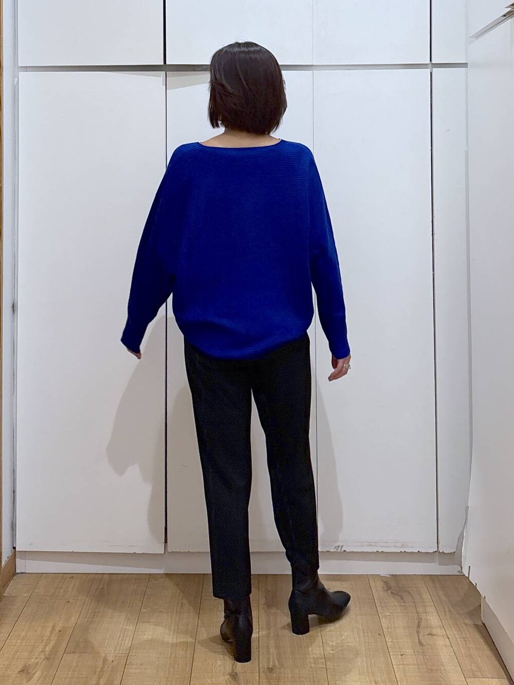 ブラック系のその他パンツ、ブルー系のニット/セーター、ブラック系のブーツを着用したレディースの秋コーディネートの3枚目の写真