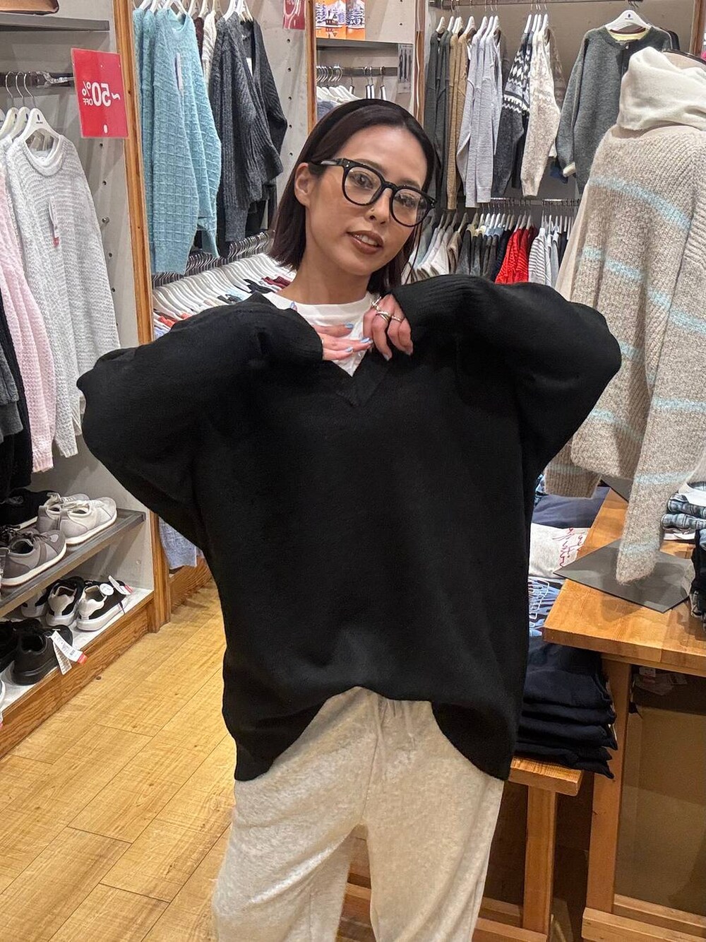 ブラック系のボストンバッグ、ブラック系のニット/セーター、ホワイト系のTシャツ/カットソーを着用したレディースの冬コーディネートの4枚目の写真