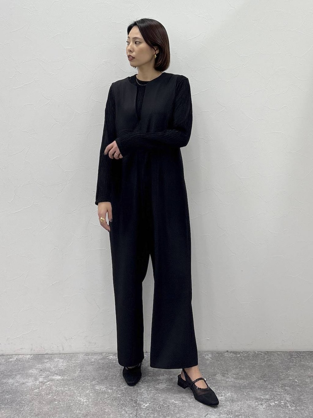 ブラック系のTシャツ/カットソー、ブラック系のサロペット/オーバーオール、ゴールド系のピアス（両耳用）を着用したレディースの冬コーディネートの2枚目の写真