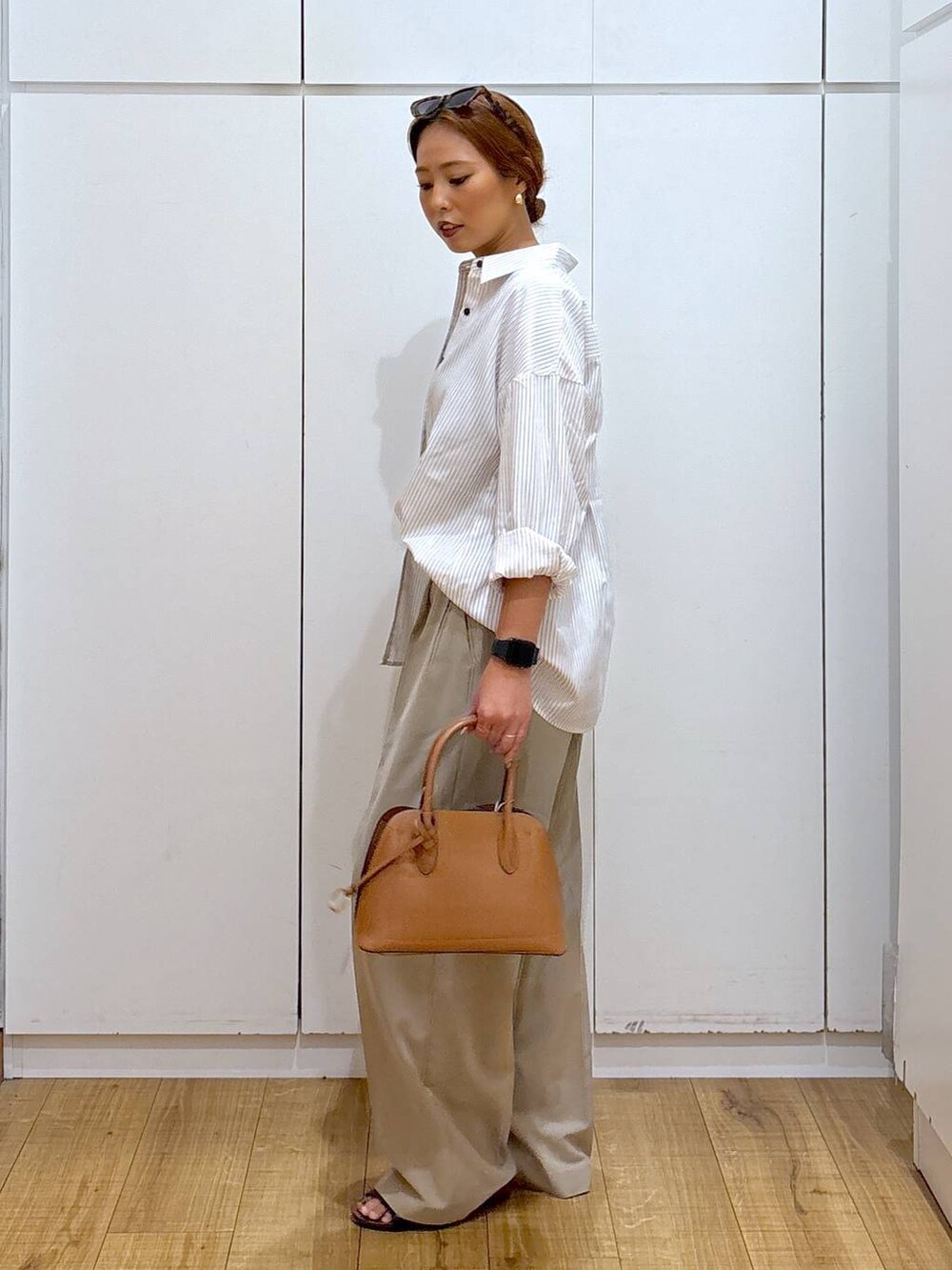 ブラウン系のショルダーバッグ、ベージュ系のその他パンツ、その他のシャツ/ブラウスを着用したレディースの秋コーディネートの5枚目の写真