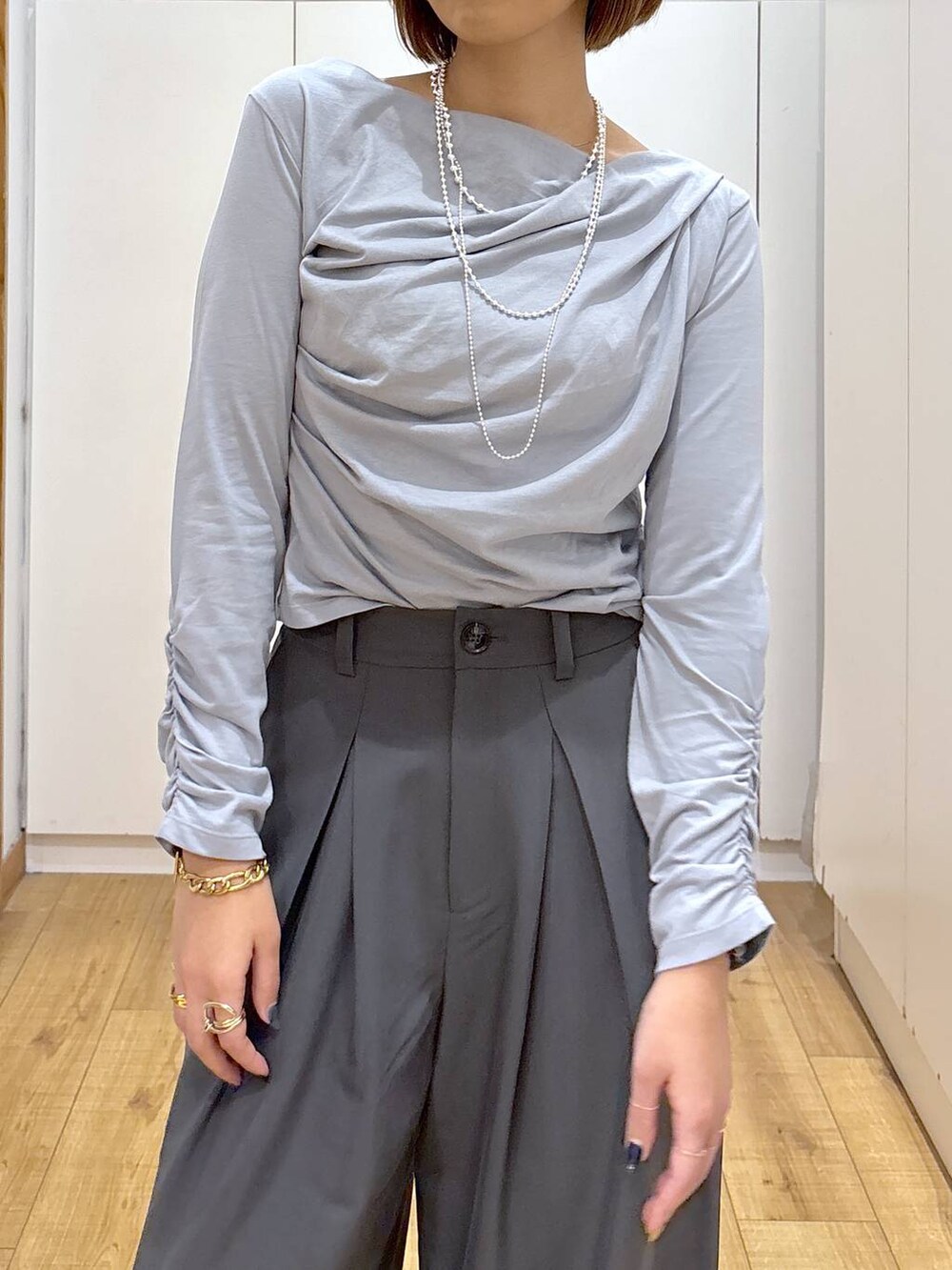 シルバー系のパンプス、グレー系のTシャツ/カットソー、グレー系のスラックスを着用したレディースの秋コーディネートの4枚目の写真