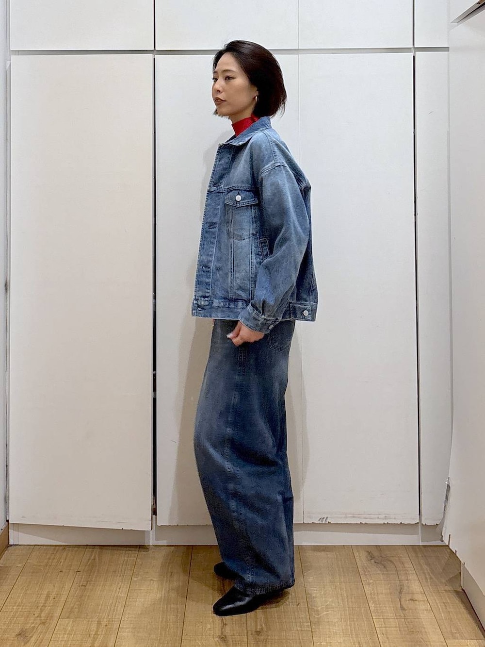 レッド系のニット/セーター、ブラック系のブーツ、ブルー系のデニムジャケットを着用したレディースの冬コーディネートの3枚目の写真